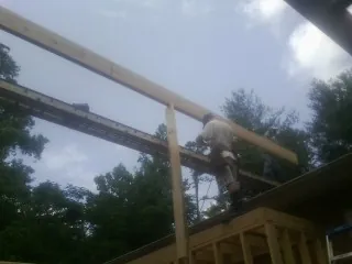 Carpenter setting a ridge beam over a new addition frame — Ice Dam Removal by Roofing Brothers in Compton