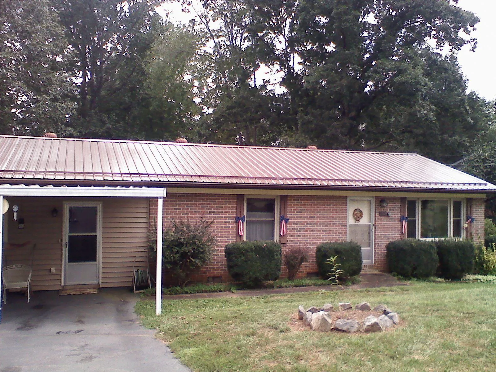 Bronze metal roof and carport on a brick ranch home — Roof Repair work by our crew in Compton